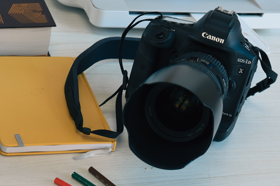 Canon 1D X Mark III junto a un bloc de notas y lápices.